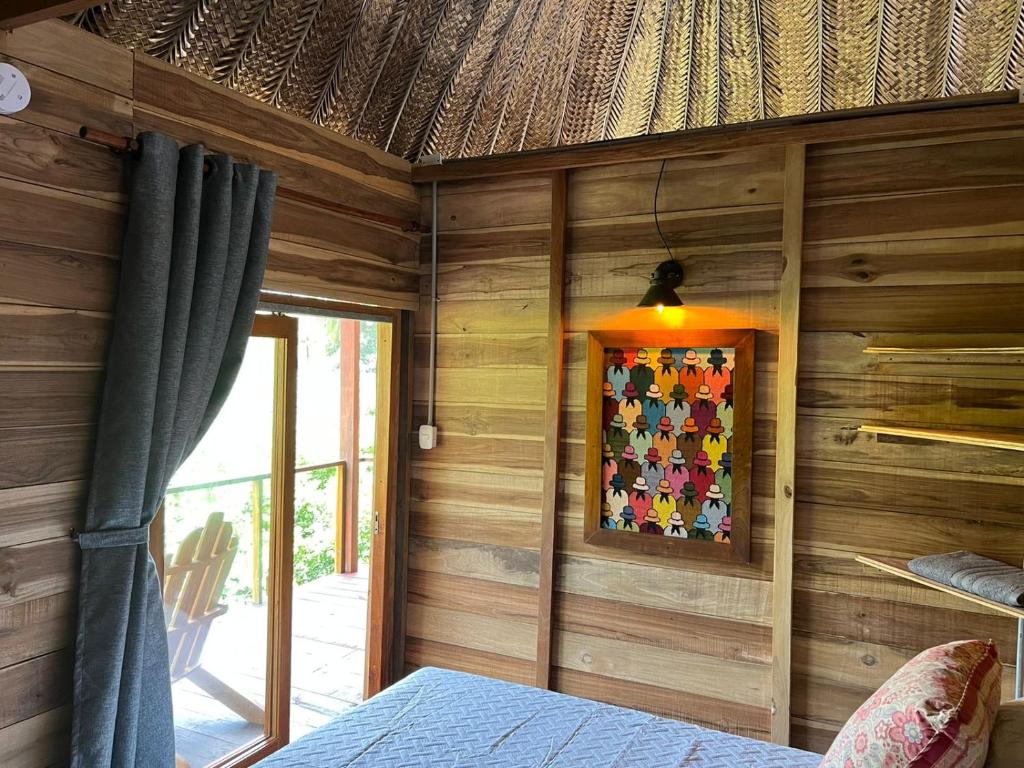 a room with a wooden wall with a bed and a lamp at Palm Beach Hostal in Santa Marta