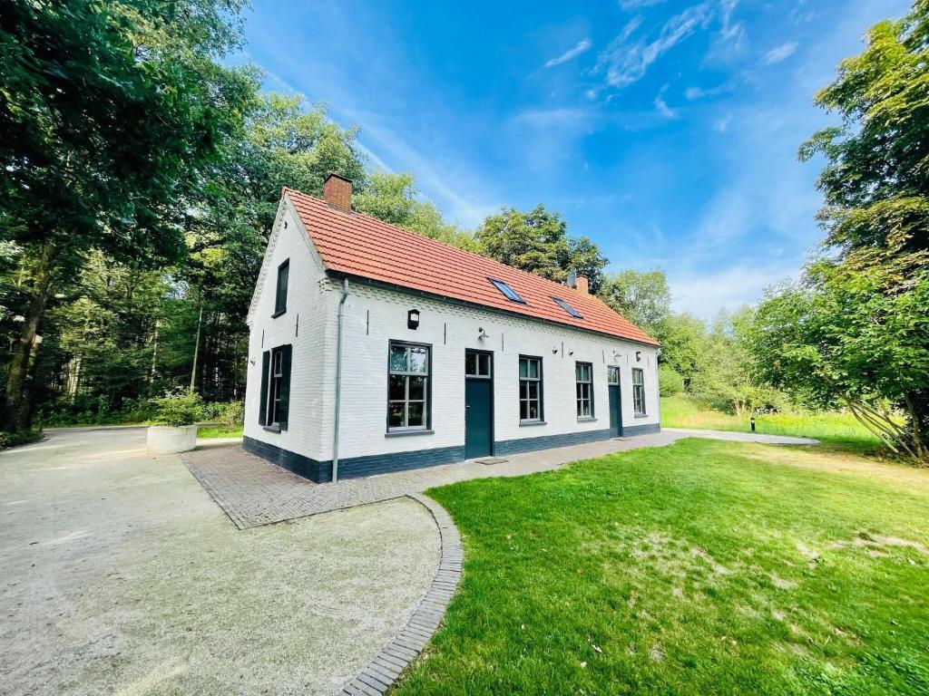 een wit gebouw met een rood dak bij Secluded Holiday Home in Erp with Garden in Erp