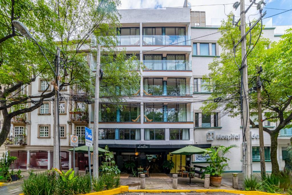 een hoog wit gebouw met bomen ervoor bij HOTEL LUCA in Mexico-Stad