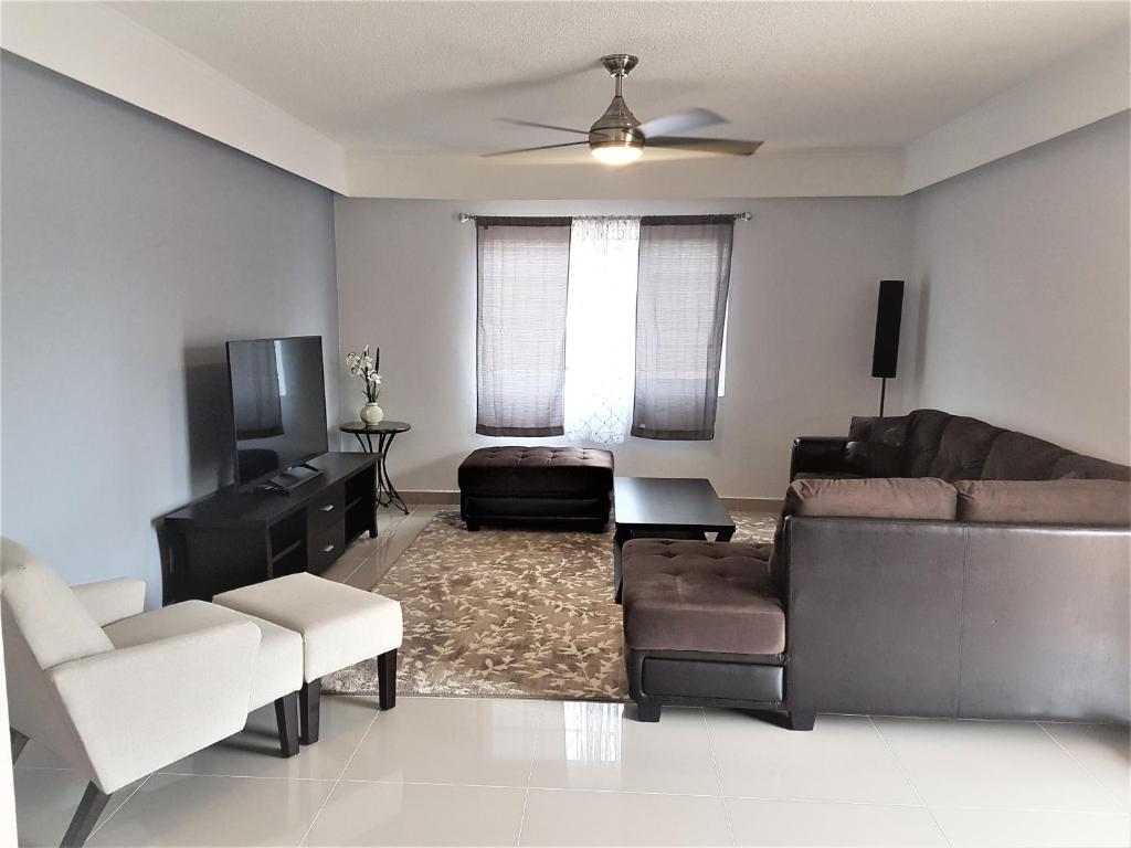 a living room with a couch and a table at Swan Boutique Apartment in Tamuning