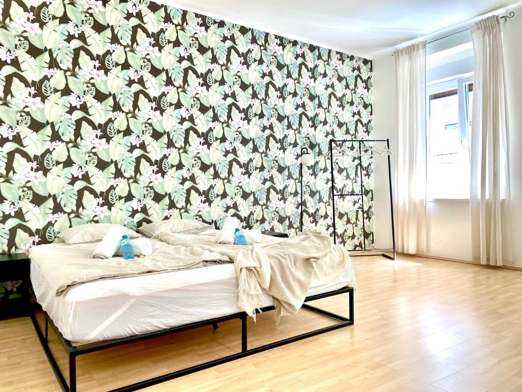 een slaapkamer met een bed met bloemenbehang bij Central Comfy Apartment - Self Check-in in Graz