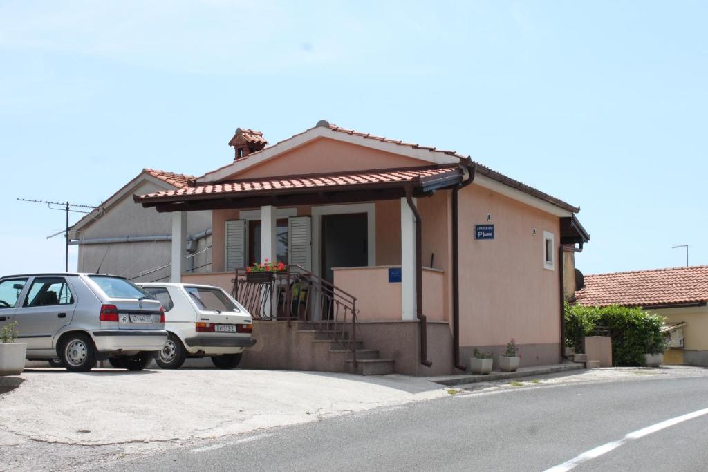 a house with two cars parked in front of it at Apartments with parking space Kraj, Opatija - 7794 in Kraj