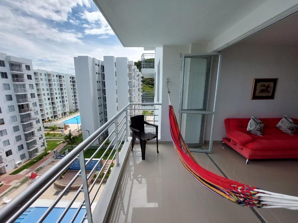 una sala de estar con una hamaca roja en el balcón en Apartamento Aqualina Orange Piso Octavo Vista a Piscina, en Girardot