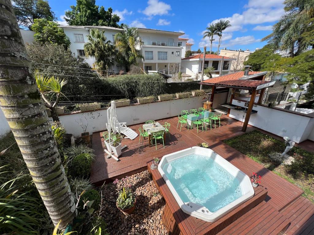 a backyard with a hot tub and a table and chairs at Becas House in Sao Paulo