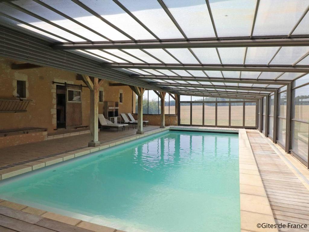 a swimming pool with a retractable pergola over it at Gîte Rémalard, 6 pièces, 14 personnes - FR-1-497-164 in Rémalard