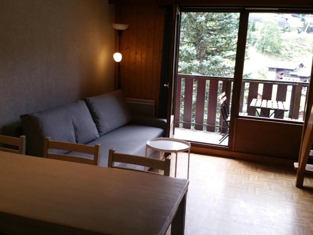 a living room with a couch and a balcony at Appartement La Clusaz, 3 pièces, 6 personnes - FR-1-459-191 in La Clusaz