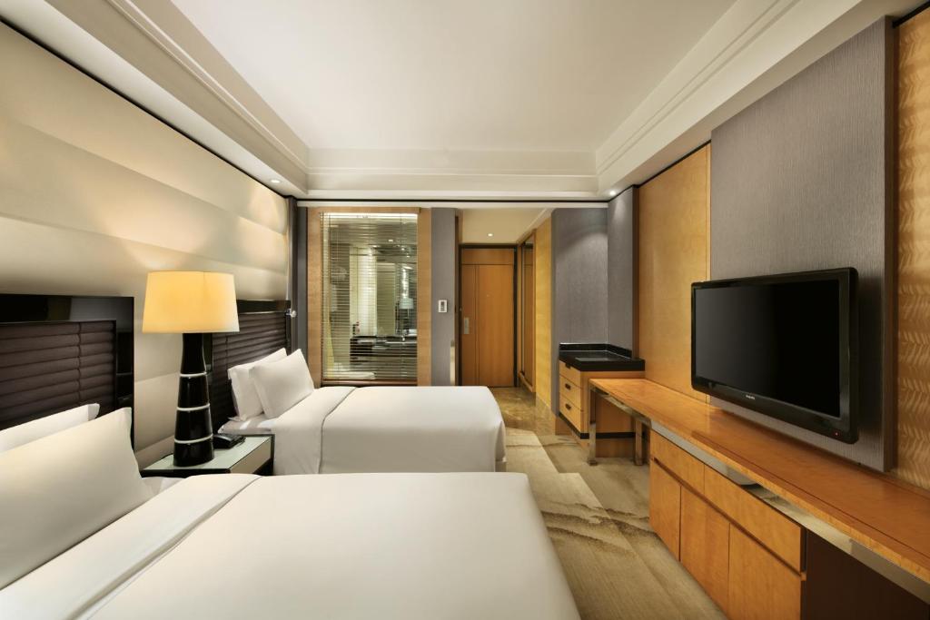 a hotel room with two beds and a flat screen tv at Crowne Plaza Chengdu City Center by IHG in Chengdu