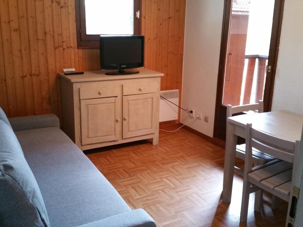 un salon avec un canapé, une télévision et une table dans l'établissement Charmant T2 avec balcon au cœur de La Clusaz, proche commerces et pistes - 4 pers. - FR-1-459-192, à La Clusaz