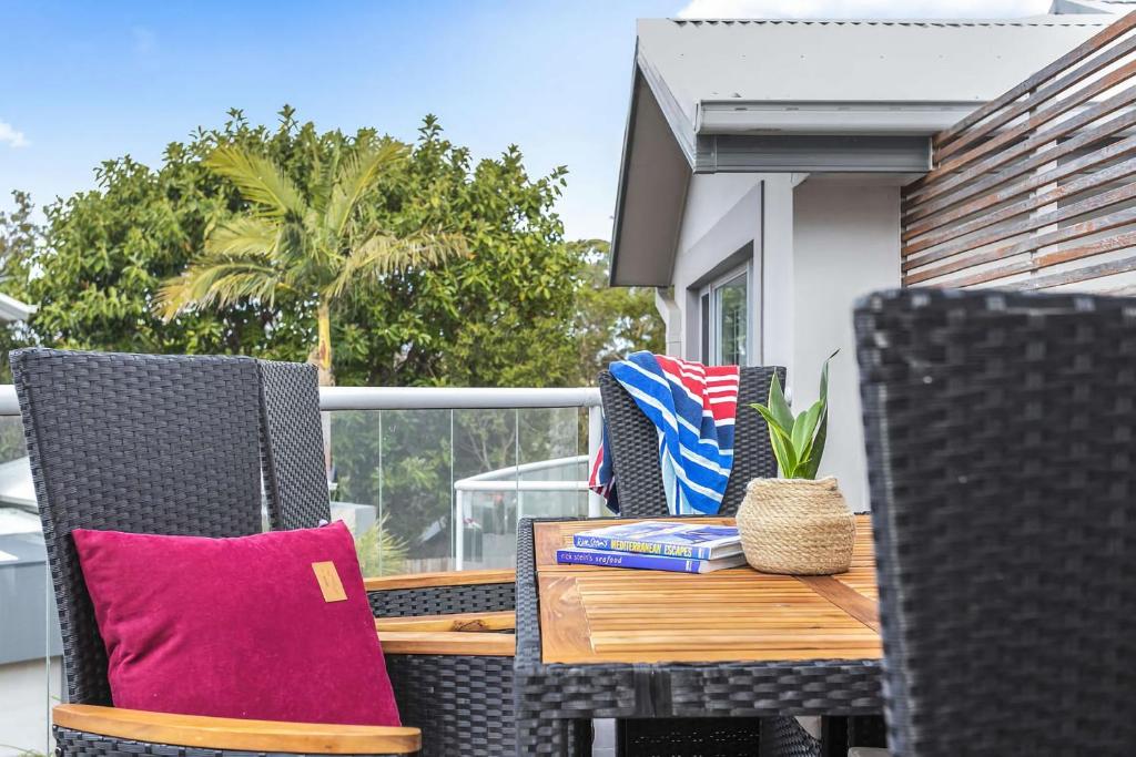 een houten tafel en stoelen op een patio bij North Harbour in Ulladulla