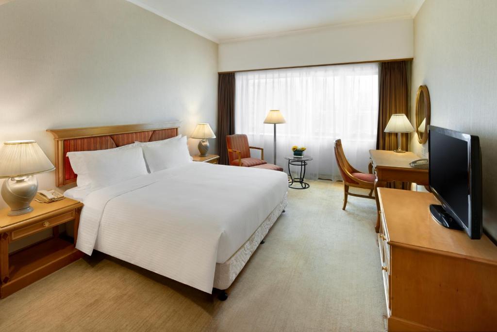 a hotel room with a large white bed and a television at Crowne Plaza Chengdu City Center by IHG in Chengdu
