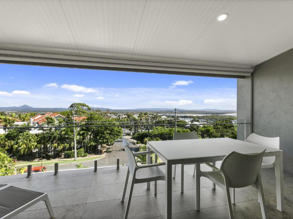 een eetkamer met een tafel en stoelen op een balkon bij Unit 3 Taralla 18 Edgar Bennett Avenue Noosa Heads in Noosa Heads