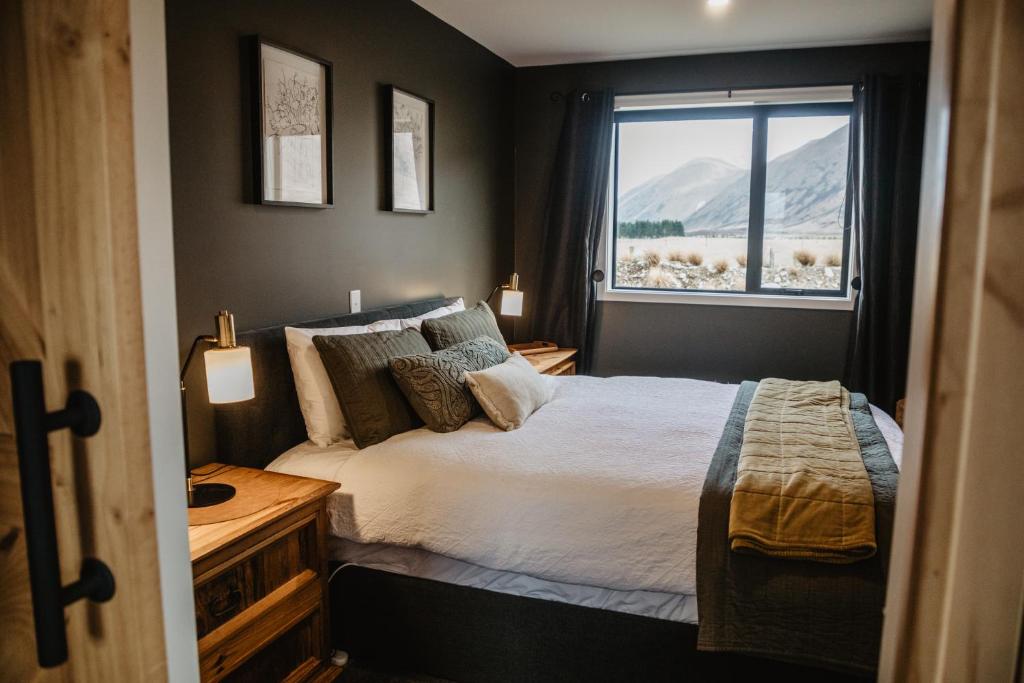 a bedroom with a bed and a window at Peak View Cabin - Ben Ohau - Stylish Seclusion in Twizel