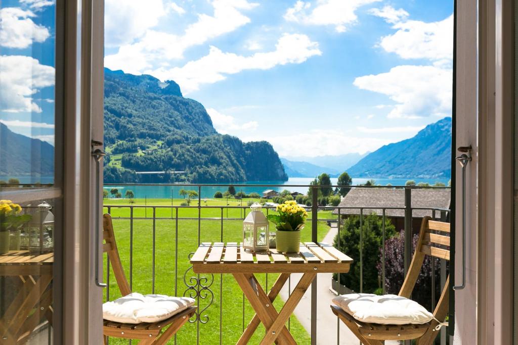 a balcony with a table and chairs and a view of a lake at Spirit Apartments - Balkon mit Seesicht - Parkplatz in Brienz