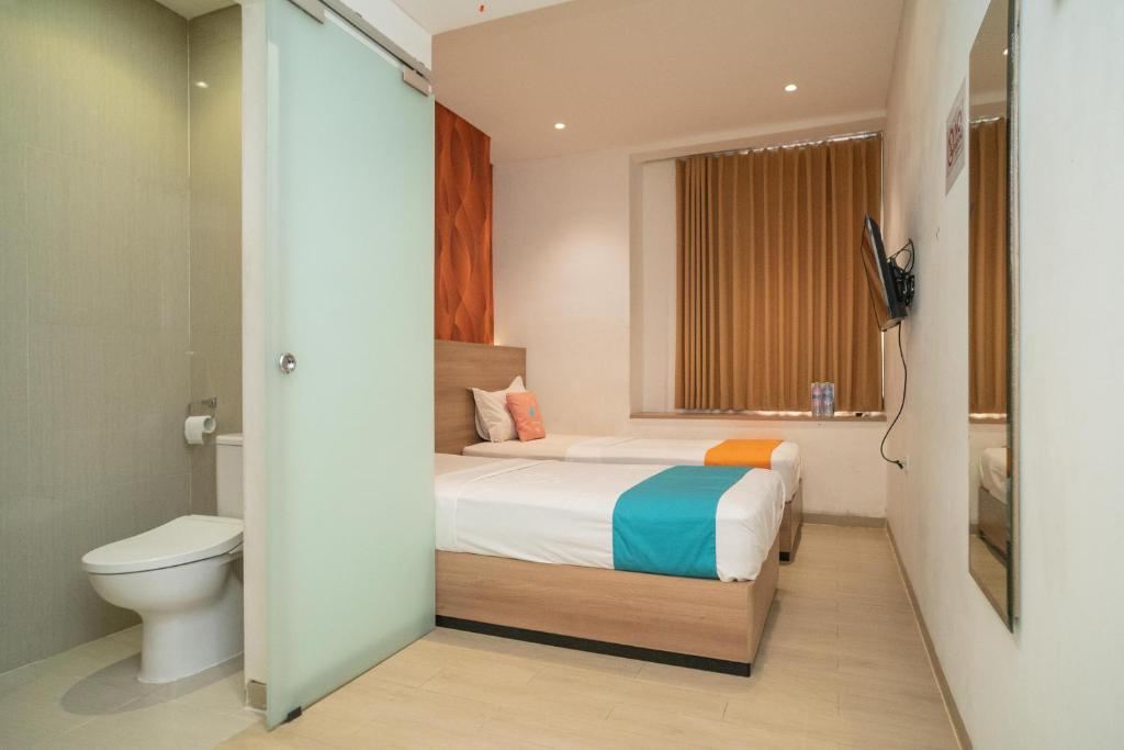 Postel nebo postele na pokoji v ubytování Sans Hotel Kupang Indah Surabaya by RedDoorz