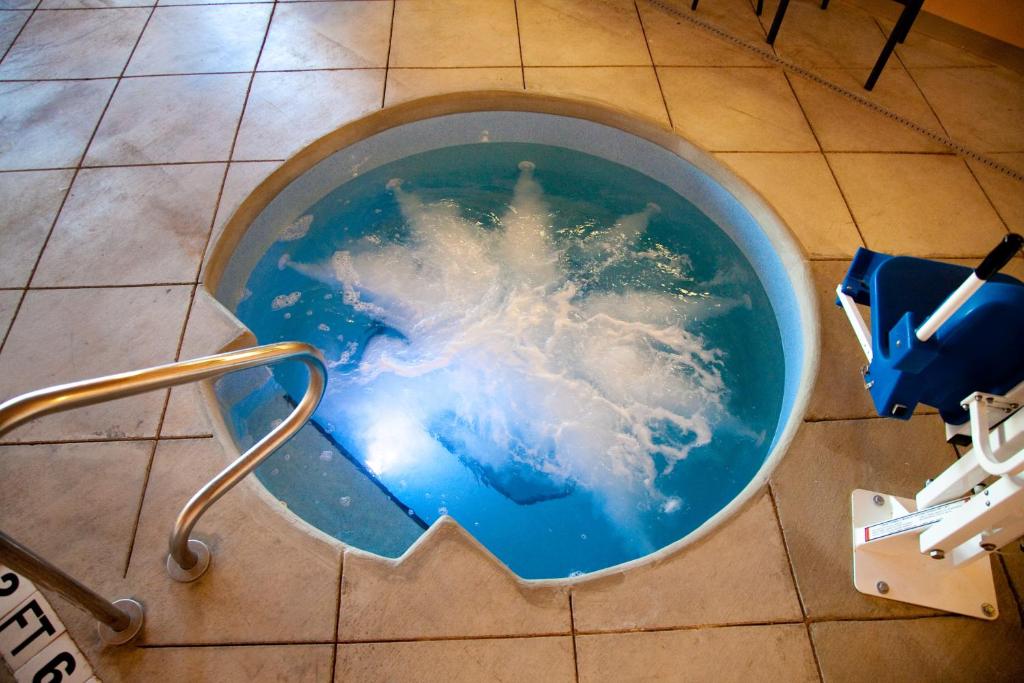 a blue bucket filled with water on a tile floor at Baymont by Wyndham Rapid City in Rapid City