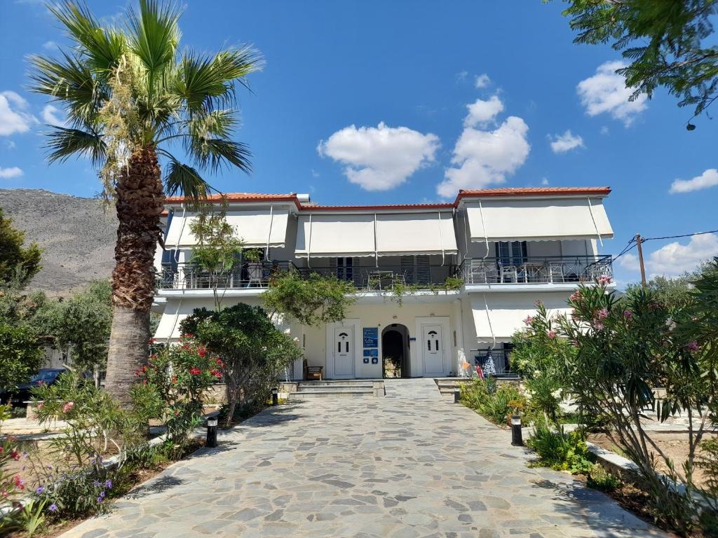 una palmera frente a un edificio blanco en Elea Guesthouse, en Galaxidhion