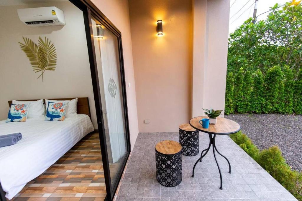 Ban Phang PhraoにあるSummer Sea Villa Khanom ซัมเมอร์ซีวิลล่า ขนอมのベッド、テーブル、鏡が備わる客室です。