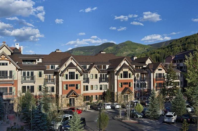 a group of buildings with cars parked in a parking lot at Luxury Ski In, Ski Out 3 Bedroom Mountain Residence In The Heart Of Lionshead Village With Heated Slope Side Pool And Hot Tub in Vail
