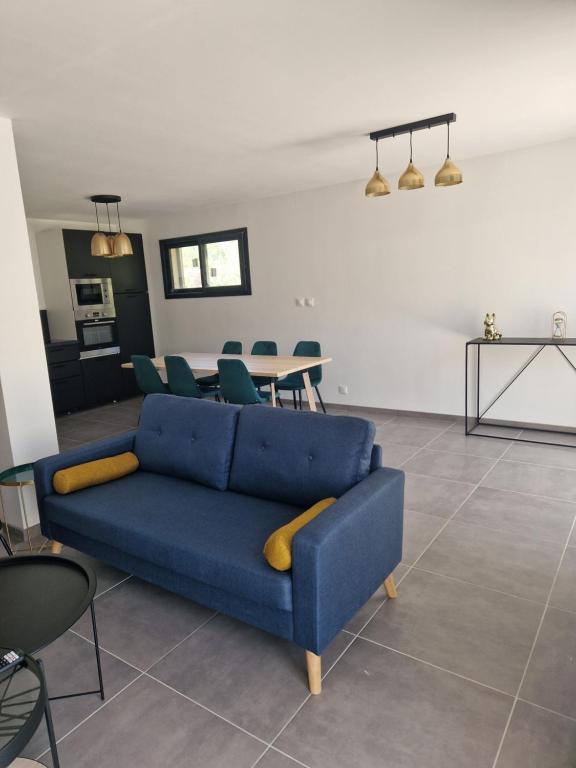 uma sala de estar com um sofá azul e uma mesa em Villa Nomy em Grandes Sables