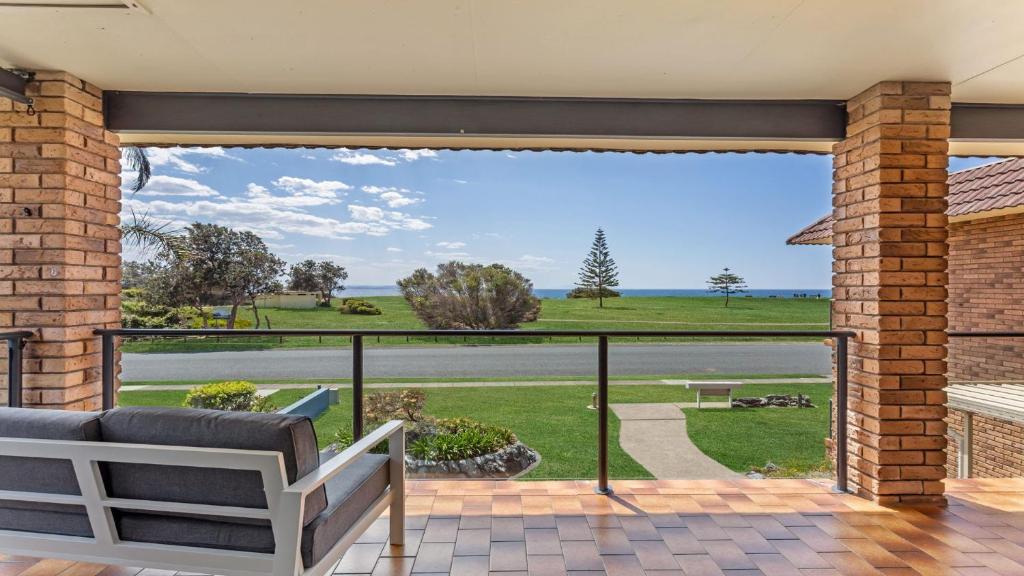 a patio with a view of the ocean from a house at Surfspray 4 Pebbly Beach in Forster