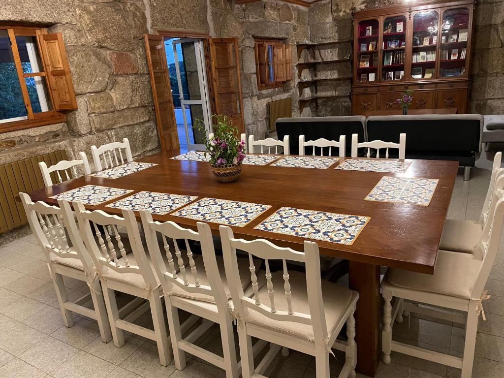 drewniany stół z białymi krzesłami wokół niego w obiekcie VILLA en PLAYA LIMENS w mieście Cangas de Morrazo
