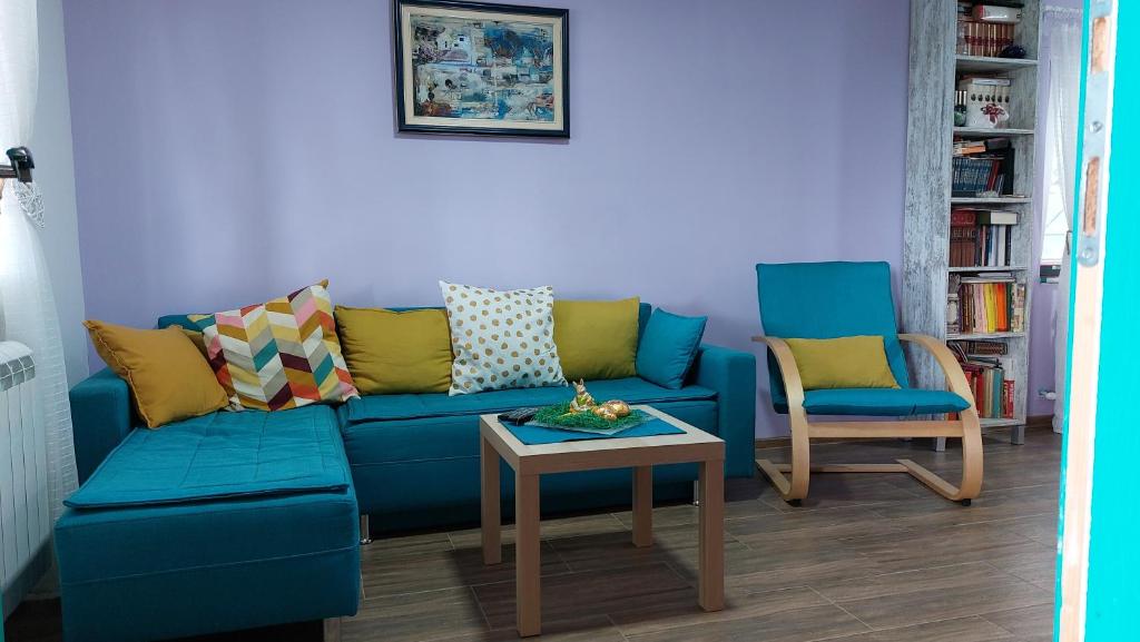 a living room with a blue couch and two chairs at Vila Largo in Donja Mala