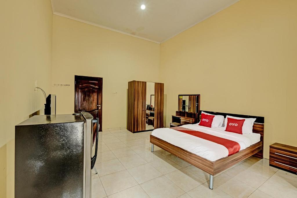 a bedroom with a bed with red pillows at OYO 91522 Candi Gebang Guesthouse in Seturan