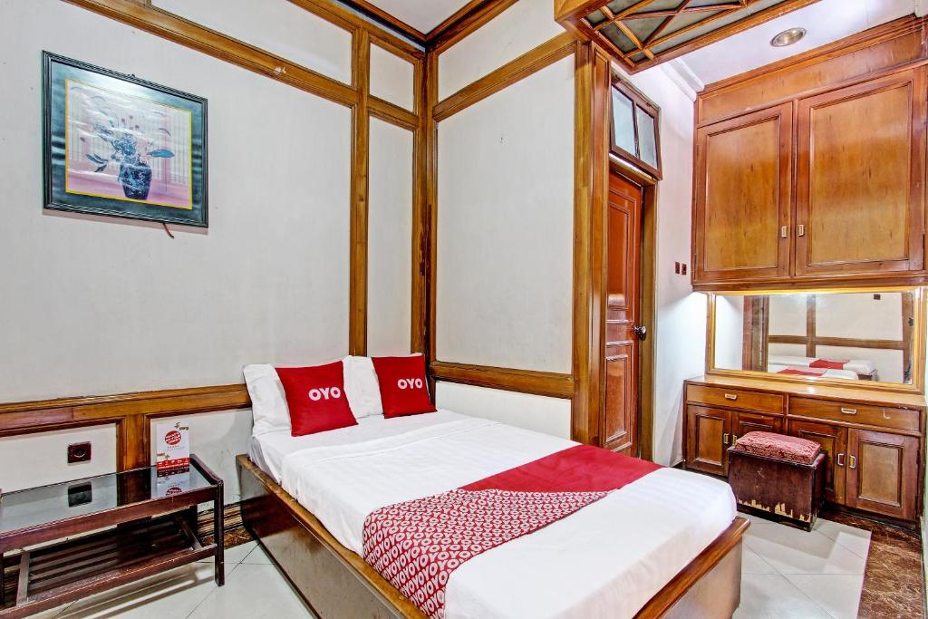 a bedroom with a bed with red pillows at OYO 91525 Hotel Bugisan in Ngabean