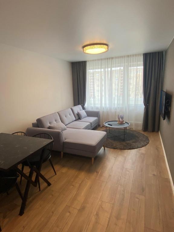 a living room with a couch and a table at ETG Apartment in Mažeikiai