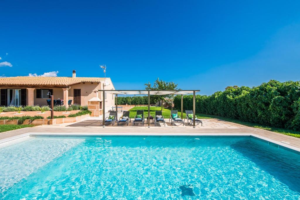 a swimming pool in front of a house at Villa del Nord in Sa Pobla