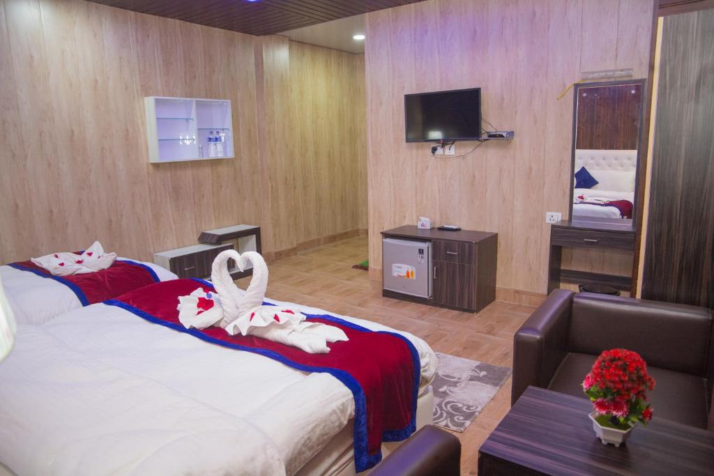 a hotel room with a large bed and a television at Hotel Span in Butwāl