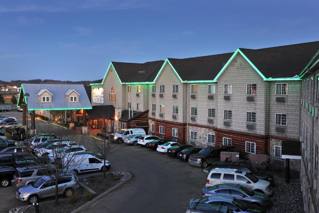 Stoney Creek Hotel La Crosse - Onalaska في Onalaska: موقف للسيارات مع وقوف السيارات أمام المبنى