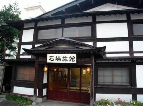 a black and white building with a sign in front of it at Ishiba Ryokan in Hirosaki