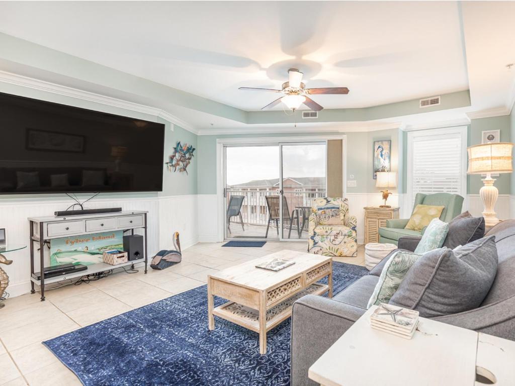 a living room with a tv and a couch and a table at Gull Reef 633 in Tybee Island