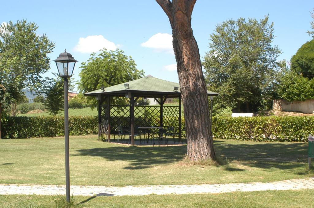 park z altaną i drzewem w obiekcie Albergo el Rancho w mieście Bevagna