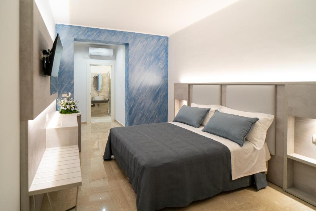 1 dormitorio con cama y pared azul en Le margherite B&B, en Mesagne