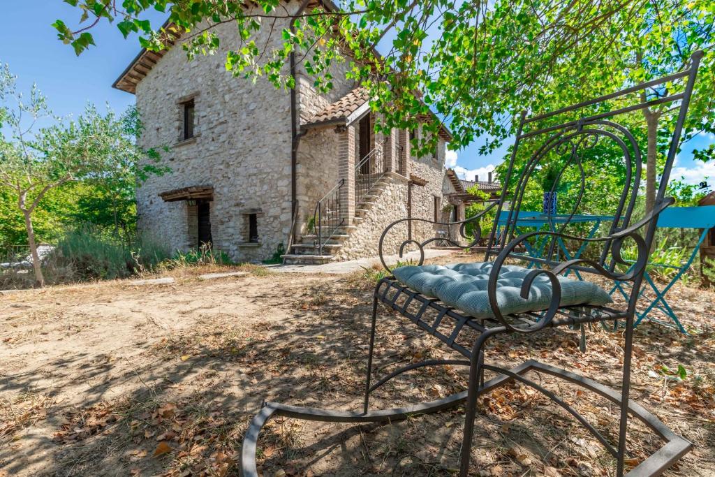 une chaise assise sous un arbre devant un bâtiment dans l'établissement Italian Experience-Casale Madreterra, à Colli sul Velino