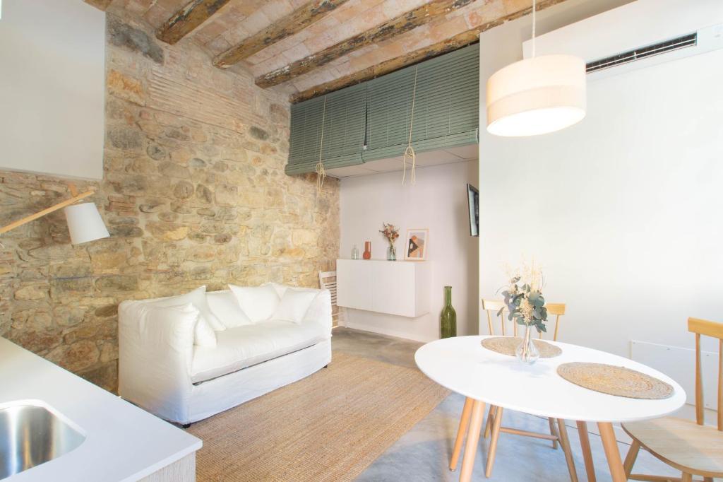 ein Wohnzimmer mit einem weißen Sofa und einem Tisch in der Unterkunft Argenta Boutique Apartment in Girona