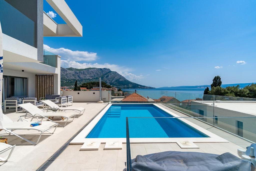 a swimming pool on the roof of a house at Luxurious VILLA LAPIS - heated pool, sauna, gym and spa, 120m to sandy beach in Omiš