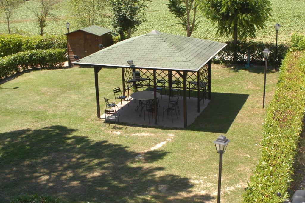 altana ze stołami i krzesłami w parku w obiekcie Albergo el Rancho w mieście Bevagna