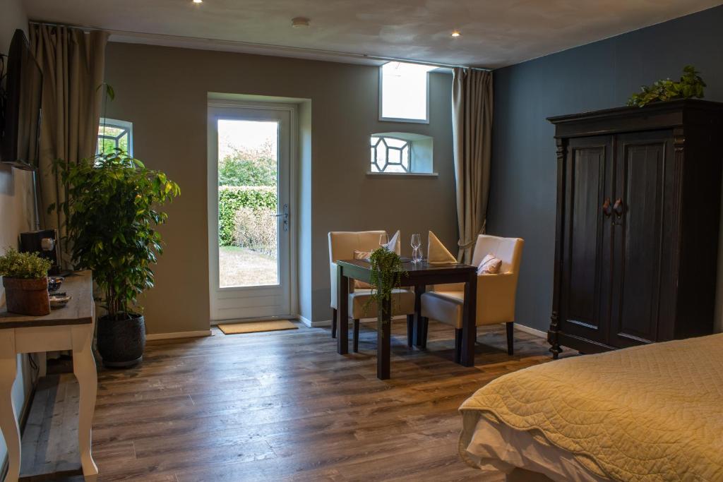 a bedroom with a bed and a table and chairs at Herberg De Fazant in Oudemolen