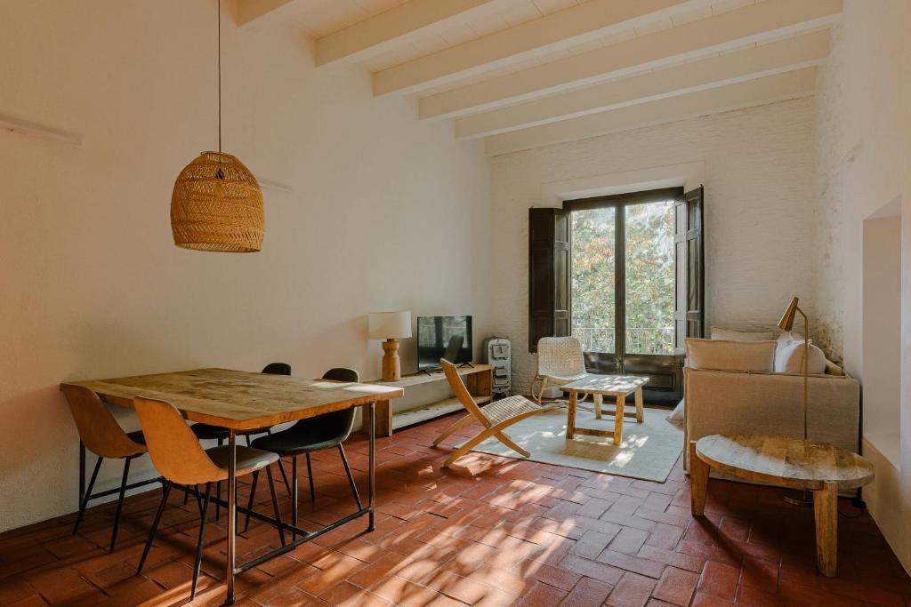 a living room with a wooden table and chairs at Flateli Santa Clara 12 in Girona