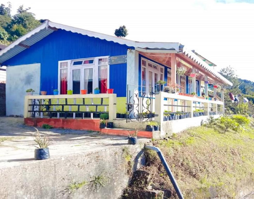 een blauw huis met een gele en rode bij Sona Homestay by StayApart in Ghum