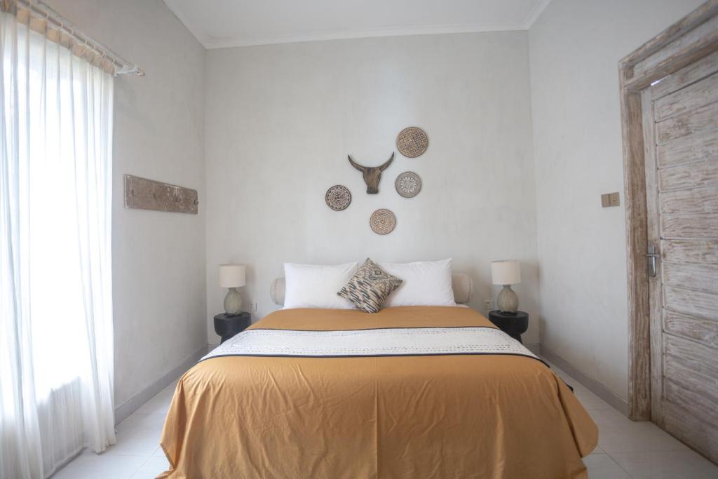 een slaapkamer met een bed met een gele deken bij Gypsy Moon Bali in Canggu