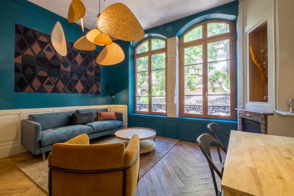 uma sala de estar com um sofá e uma mesa em HONORÊ SUITE SAINT NIZIER em Lyon