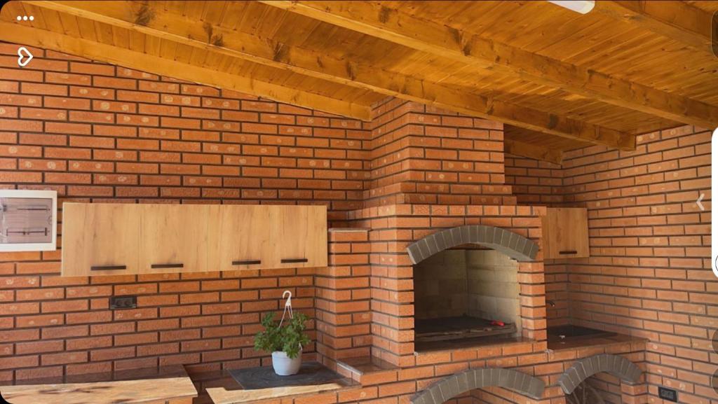 a brick fireplace with a pizza oven in it at CASA ERk in Călimăneşti
