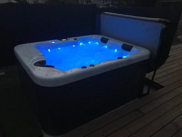 a bath tub with a blue water in it at Superbe Studio meublé idéal pour couple ZEN avec SPA in Sanguinet