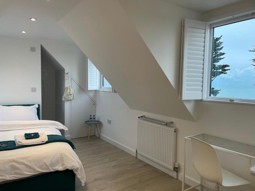 um quarto com uma cama e uma grande janela em The Bolt Hole Hythe panoramic coast and sea views em Kent