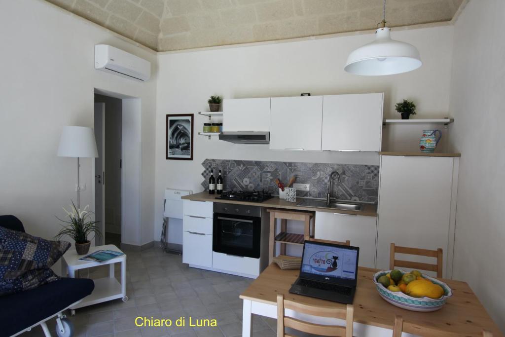 a kitchen with a table with a laptop on it at La Luna e il Gatto in Favignana