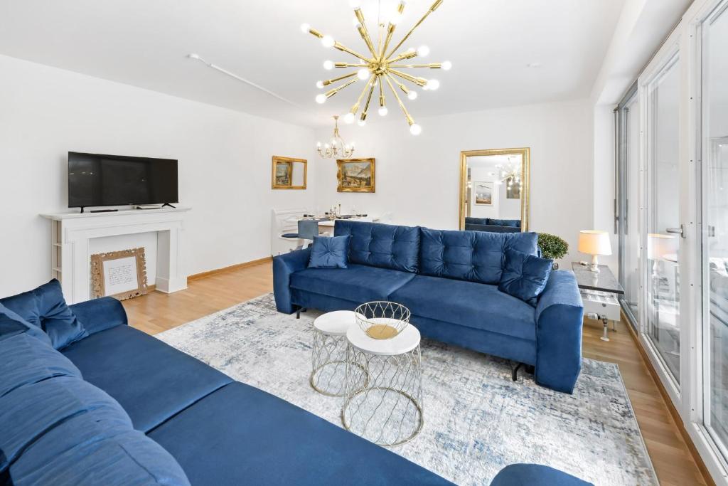 uma sala de estar com um sofá azul e uma mesa em Zwei Zimmer Wohnung im Stadtzentrum mit Tiefgaragenplatz em Munique